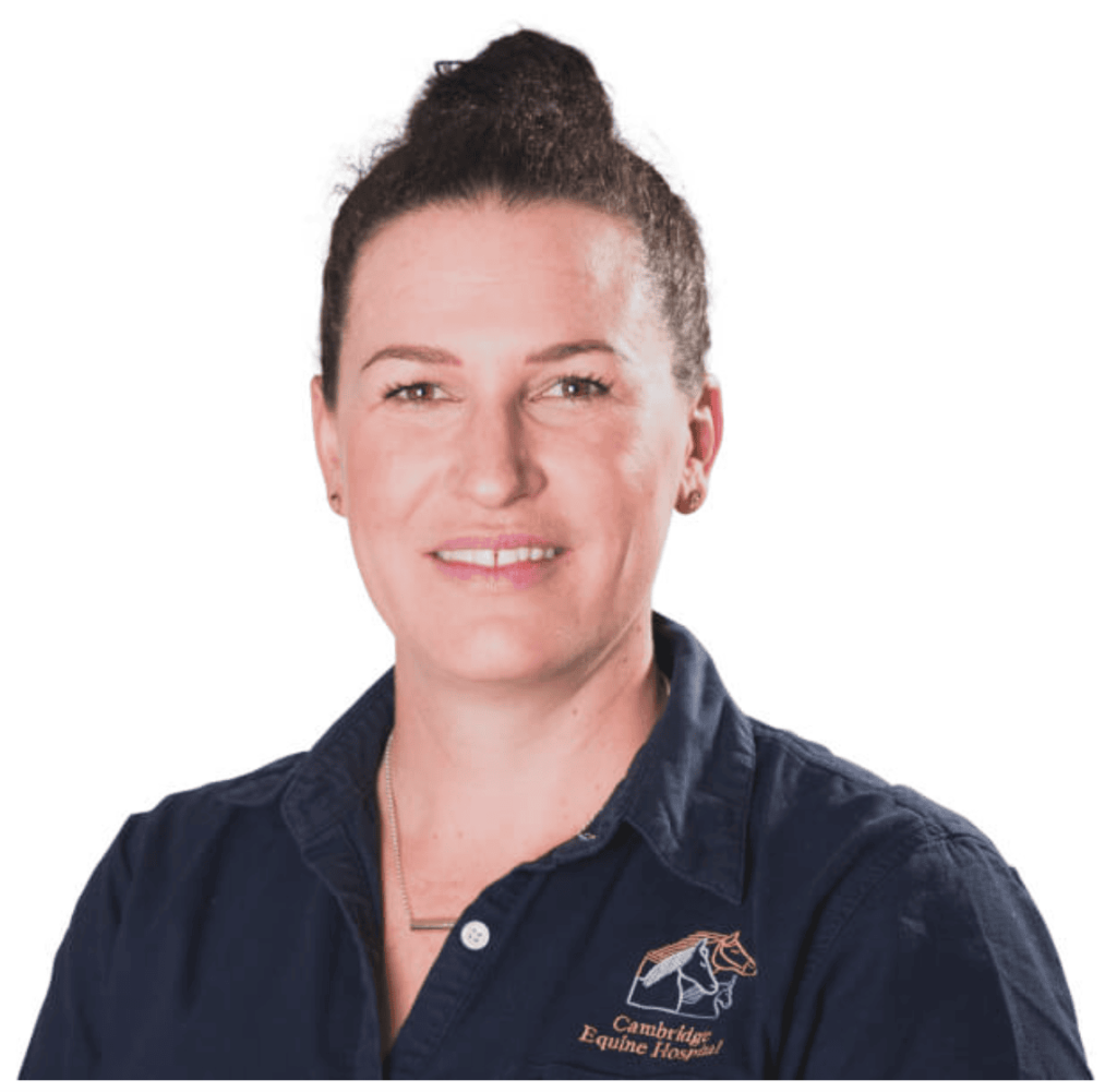 Dr. Lucy Holdaway in a navy Cambridge Equine Hospital shirt, smiling in a professional headshot on a white background.